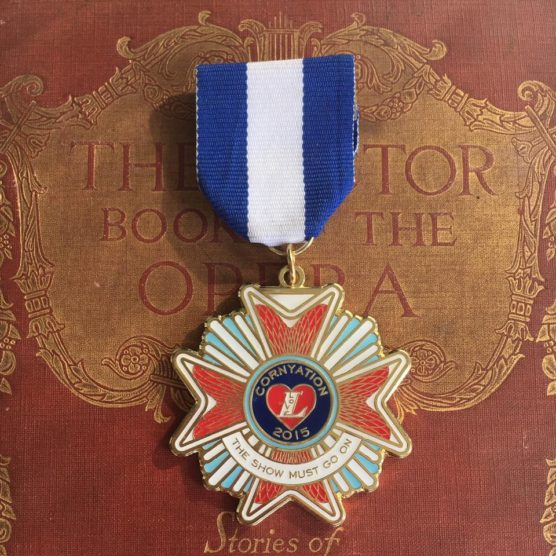 A medal is shown on top of the book.