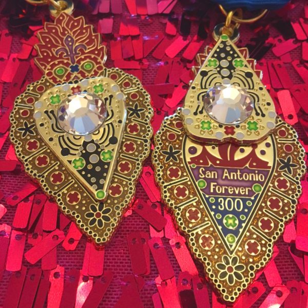 A pair of earrings with colorful designs and a mirror.