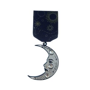 A black medal with a silver moon and sun on it.