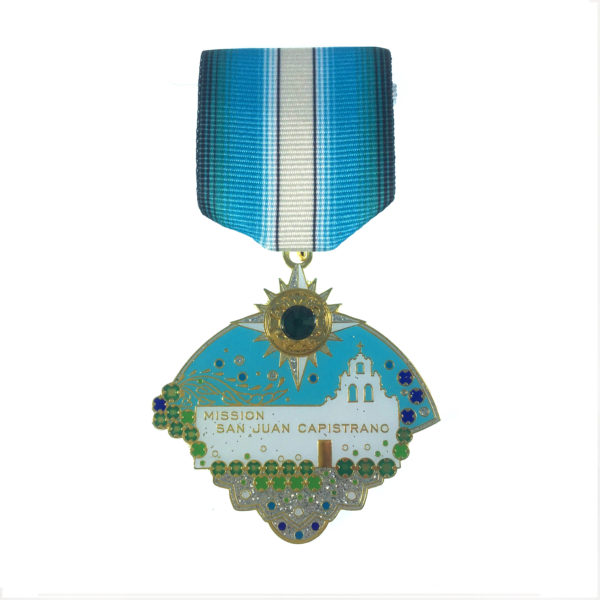 A medal with a house and sun on it.