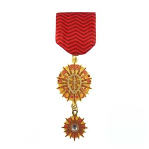 A red medal with two medals hanging from it.