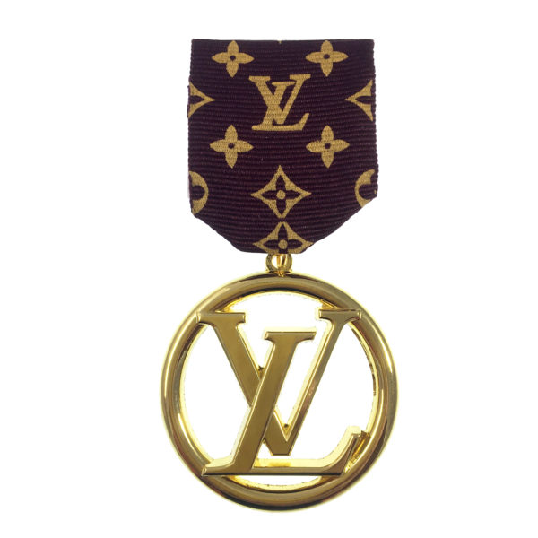 A gold medal with the letters lv on it.