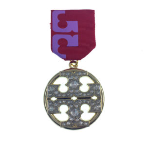 A medal with a purple ribbon and a silver circle.