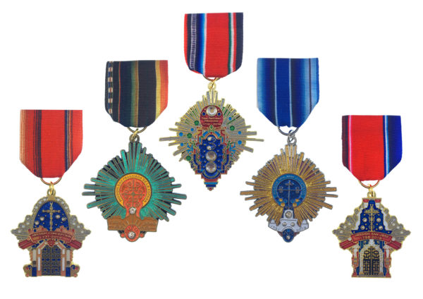 A group of six medals hanging from ribbons.