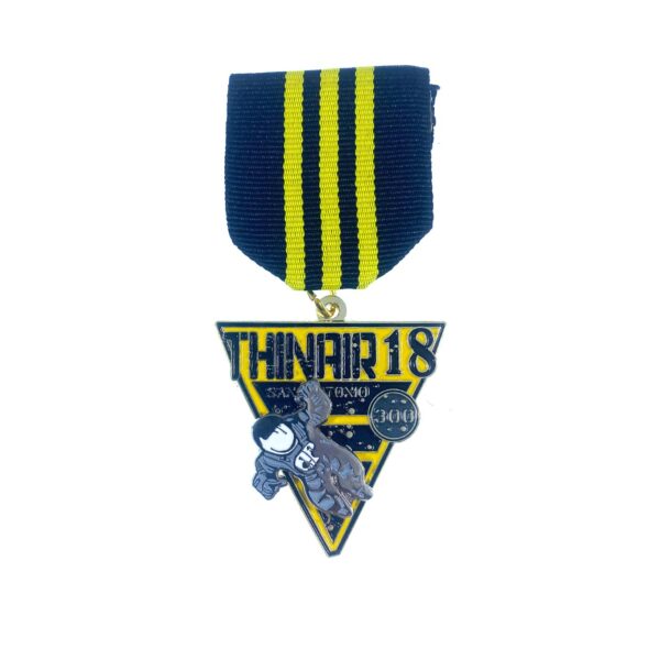 A medal with the words " thin air 1 8 ".